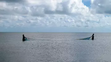 Two men mosquito net fishing in Mozambique