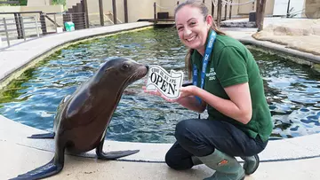 zoo-keeper-smiling-with-sea-lion-beside-pool