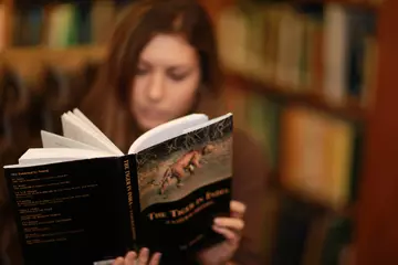 student_fellow_reading_a_book_in_library