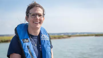 Conservationist_wearing_ZSL_lifejacket_with_estuary_in_background