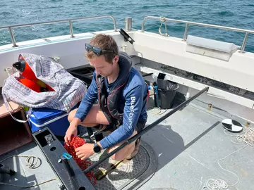 Jake Davies prepping an underwater camera on a boat