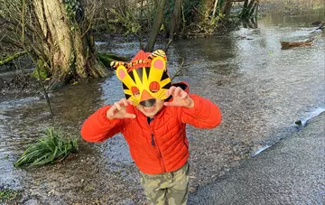 little boy in puddle with tiger mask