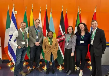 The ZSL team at COP15 standing in front of a series of flags