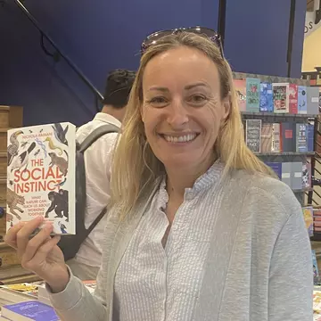 Professor Nichola Raihani with her book The Social Instict