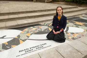 Linder, wearing a black outfit, sitting on the mosaic 