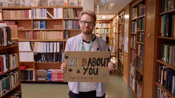 librarian holding up a thank you sign