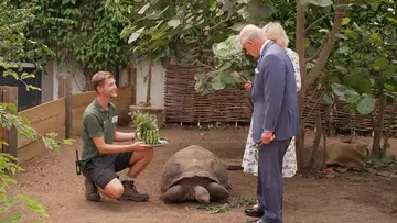 Dan Kane with watermelon bouquet next to Polly the Galapagos Tortoise and HRM King Charles and HRM Queen Camilla