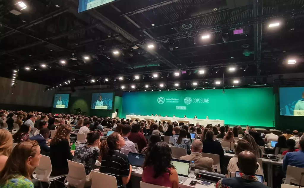 Speaker event at COP28, showing stage and audience watching