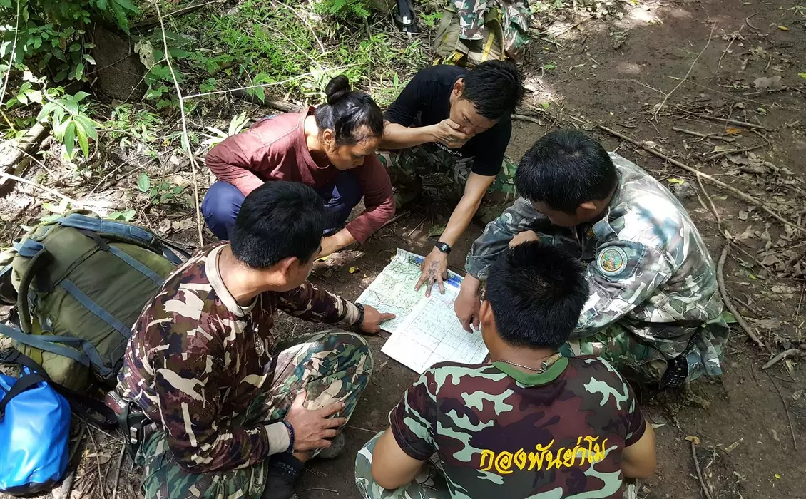 Rangers conducting elephant surveys in Thailand looking at a map 