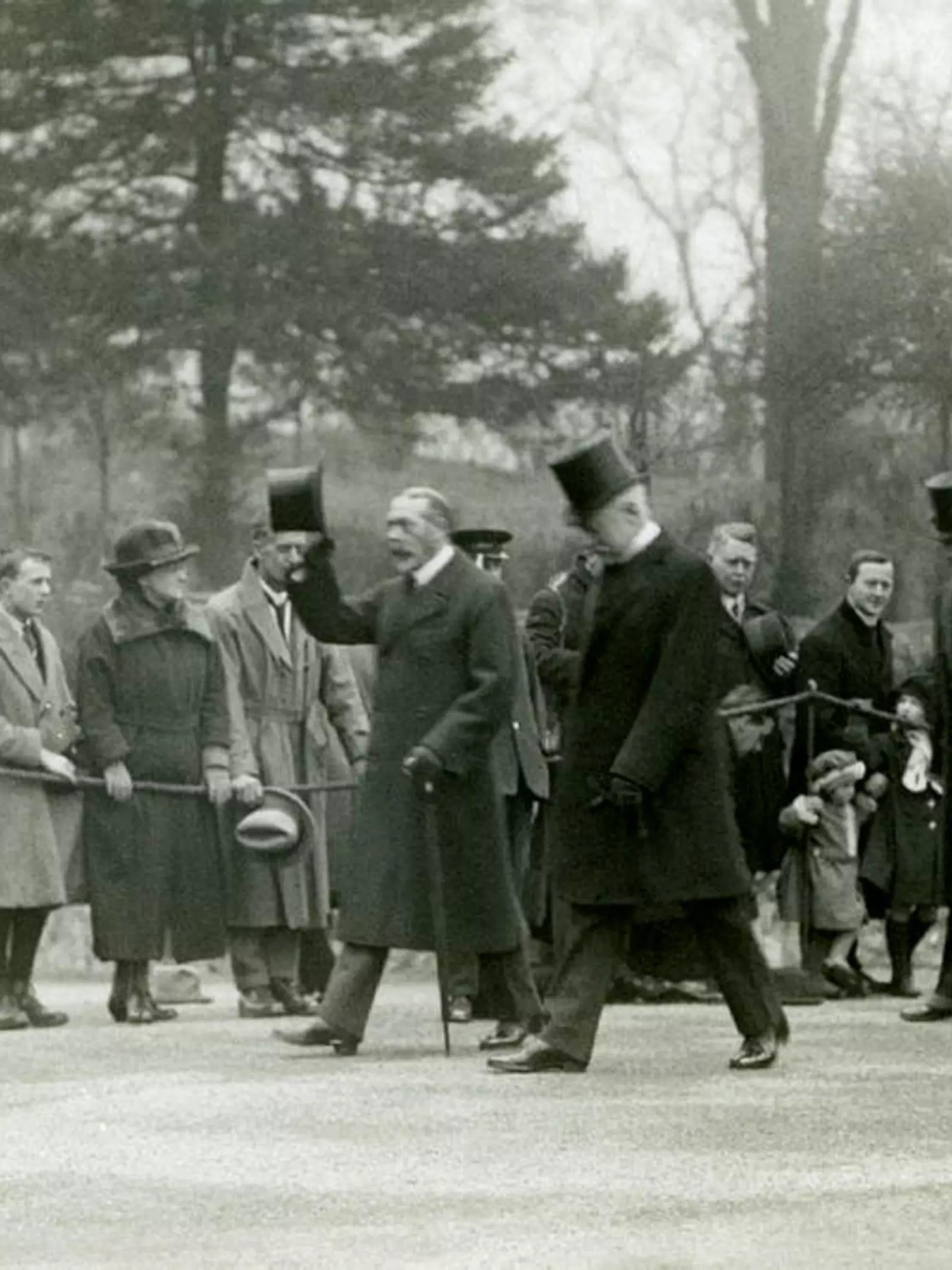 King George V, raising his hat to the crowds at the front of his entourage, during a visit to London Zoo to officially open the Aquarium. Queen Mary walks behind wearing a fur coat. The present Aquarium was built in 1921 and officially opened by King George V and Queen Mary in April 1924.