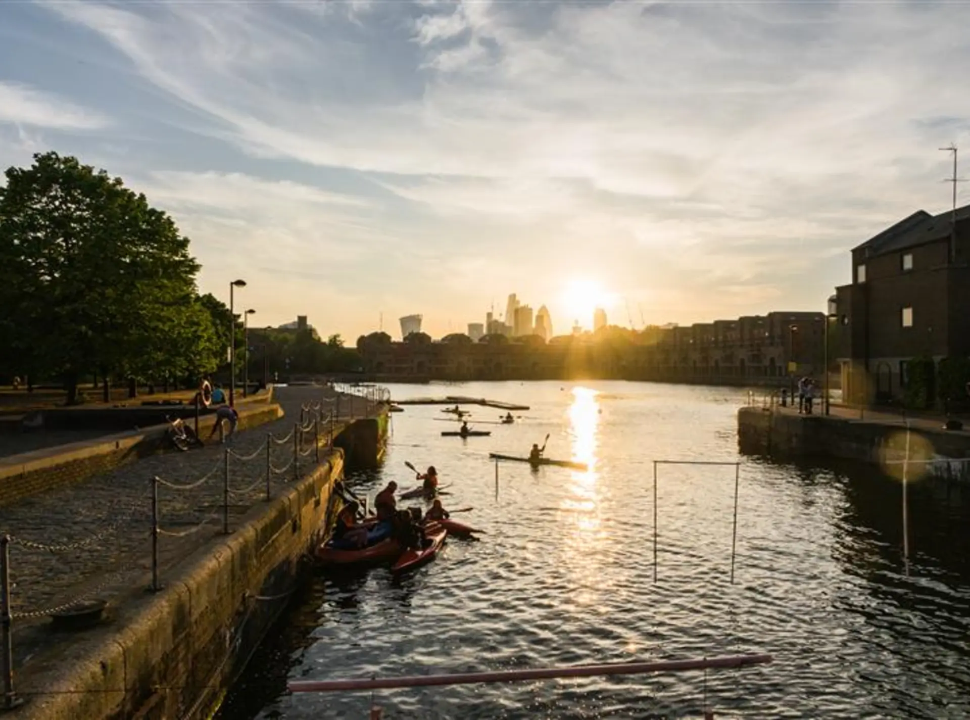 people in kayaks on the Thames during sunset