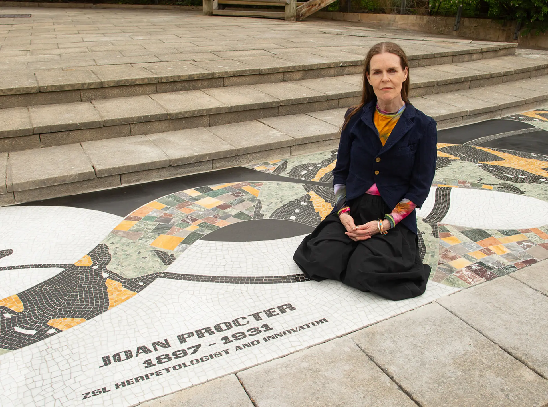 Linder, wearing a black outfit, sitting on the mosaic 