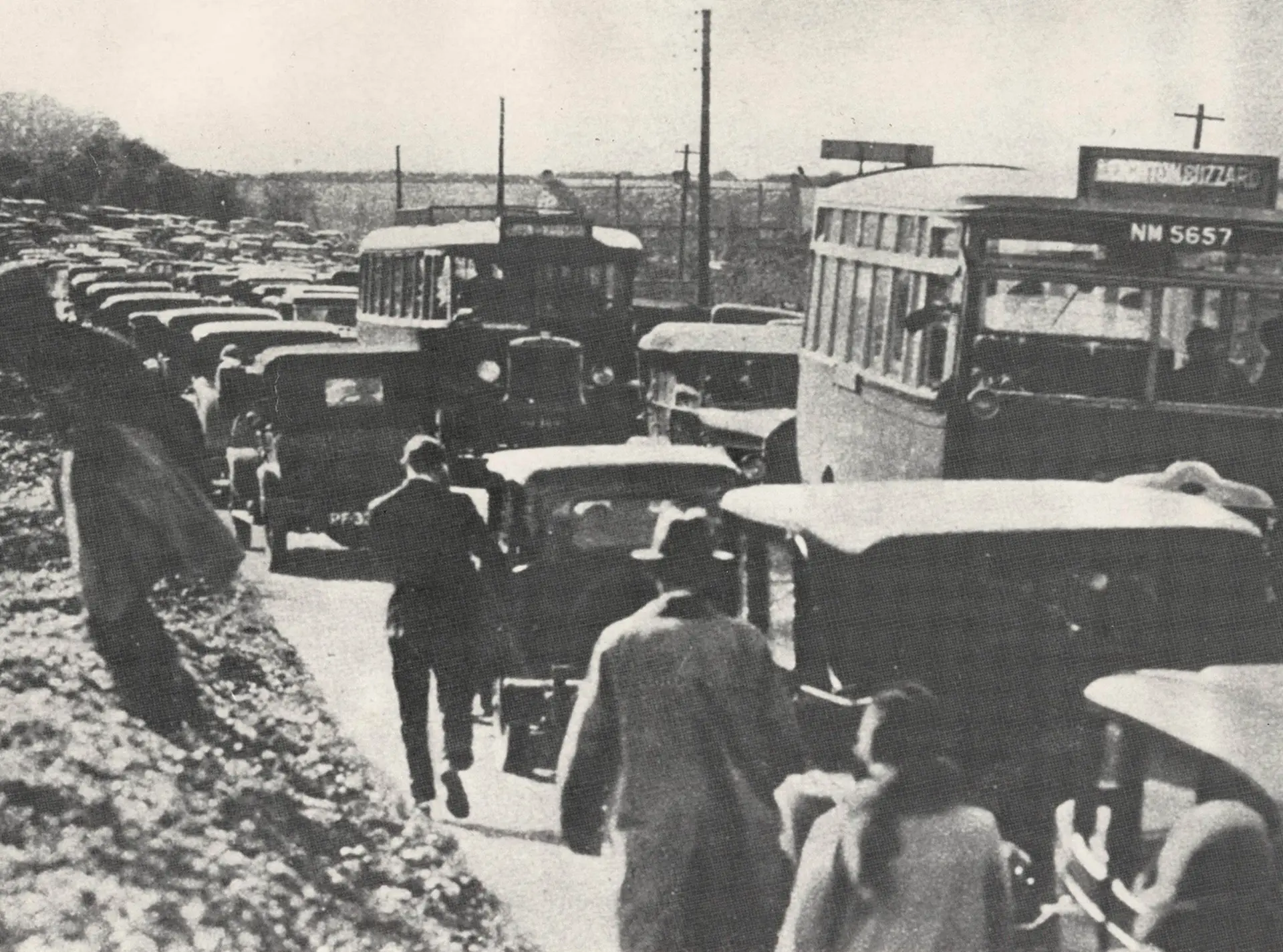 A black and white photograph of a queue of vehicles