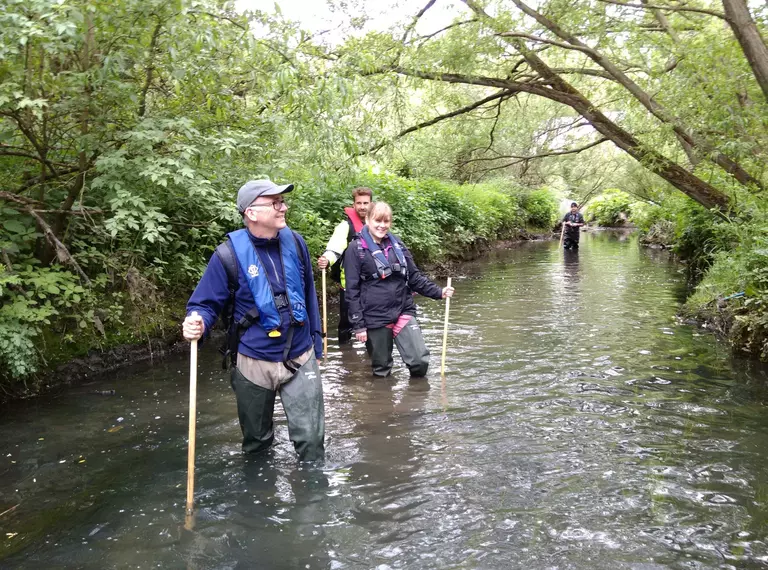 A group of citizen scientist volunteers in a river