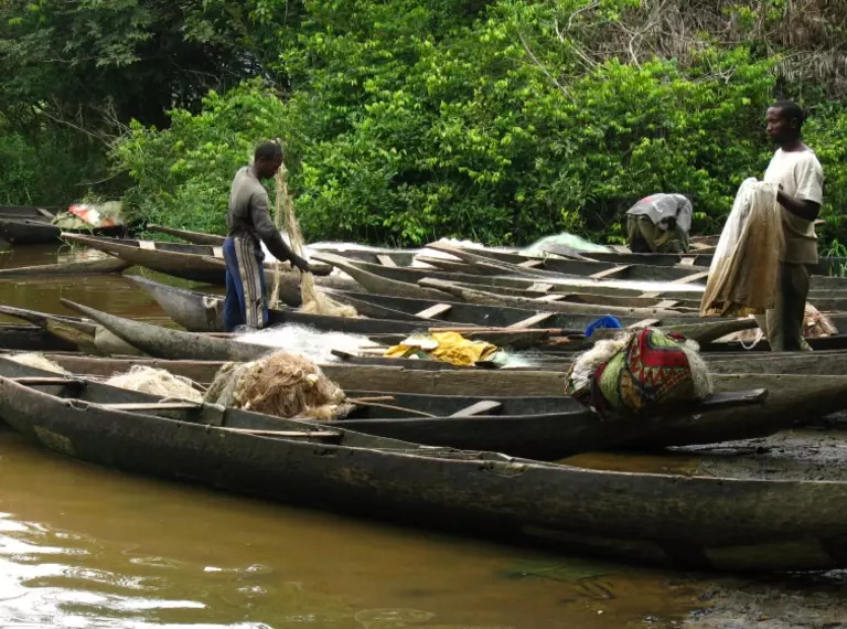 Two men with fishing nets on boats in Lake Ossa Wildlife Reserve