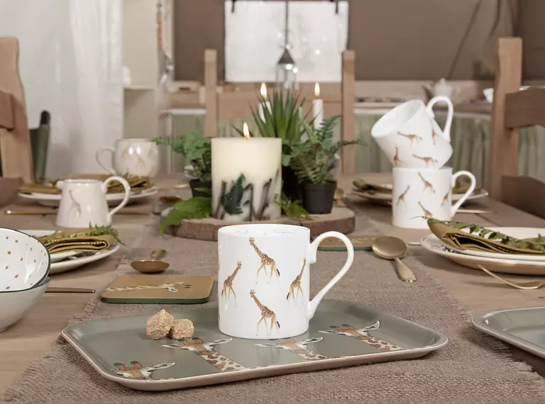 A mug and other items from the Sophie Allport giraffe collection laid out on a dining room table
