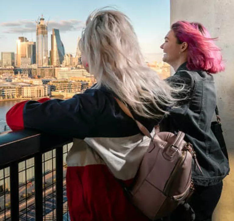 Two girls looking over the river Thames