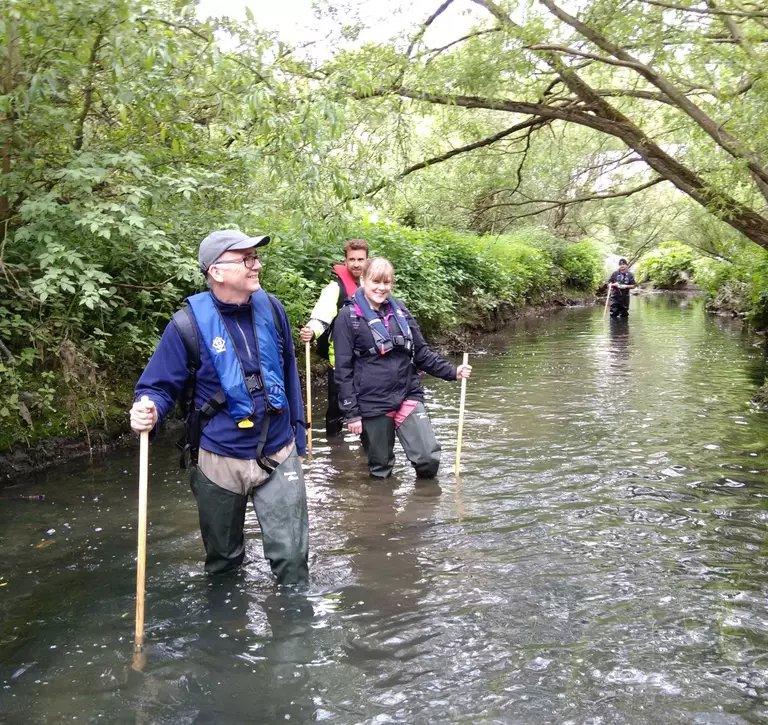 A group of citizen scientist volunteers in a river