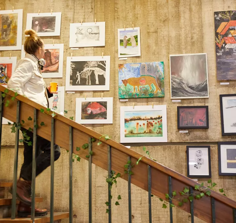 woman walking downstairs looking at art