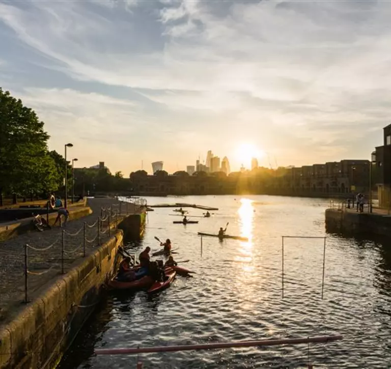 people in kayaks on the Thames during sunset
