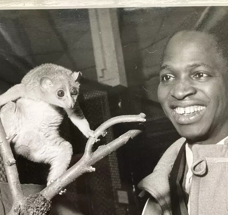A black and white photograph of a man with a small primate